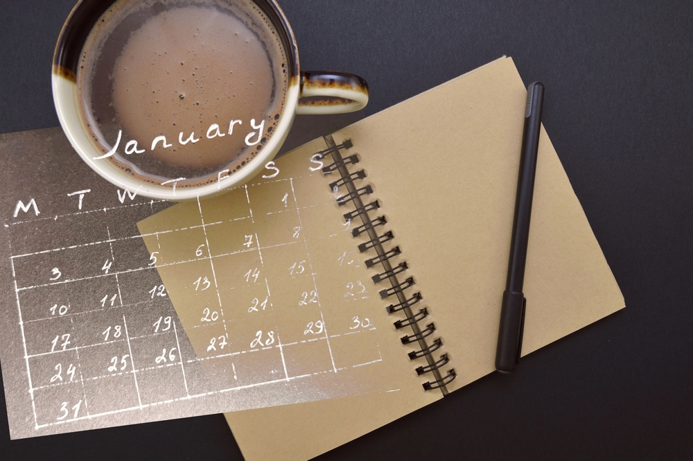 a calendar of January superimposed on a journal with pen and a yummy cup of coffee
